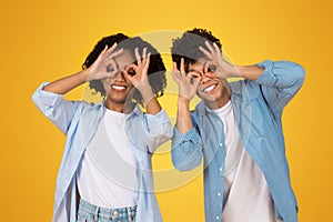 Playful and happy African American couple making binoculars with their hands