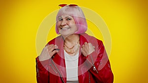 Playful happy elderly granny woman blinking eye, looking at camera with smile, expressing optimism