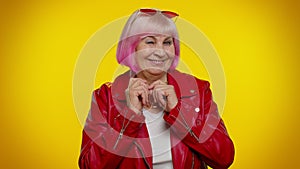 Playful happy elderly granny woman blinking eye, looking at camera with smile, expressing optimism