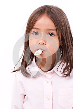 Playful, happy, smiling cute little girl eating marshmallow