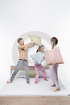 playful kids in pajamas having pillow