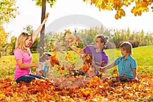 Playful kids and parents throw leaves in the air