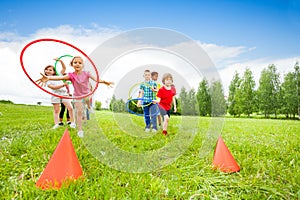 Playful kids throwing colorful hoops on cones