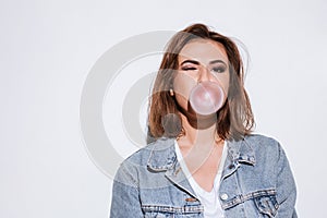 Playful lady blowing bubble with chewing gum. photo