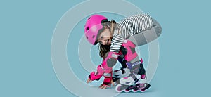 Playful little girl posing in roller skates with the helmet and gear on