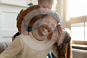 Playful little kids siblings having fun with joyful dad.