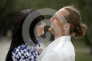 Playful love couple smiling in summer park