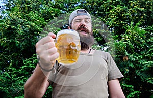 In playful mood. Brutal hipster with winking face having craft beer. Man drinker holding beer mug. Bearded man enjoy