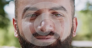 Playful mood. Close up portrait of cheerful mature bearded green-eyed man winking to camera and smiling