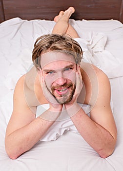 Playful mood concept. Guy macho lay white bedclothes. Pleasant relax concept. Man unshaven handsome happy smiling