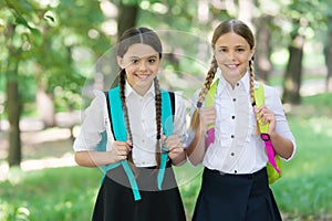 Playful mood. Fashion little girls with backpack in park. children with backpack smiling. students outside in summer