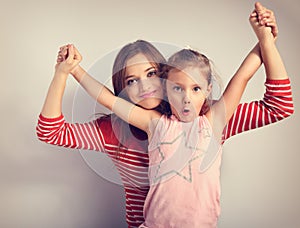 Playful mother and crazy joking grimacing kid holding each other