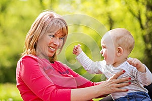 Playful mother having fun with her baby in nature