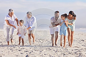 Playful multi generation family on vacation having fun at the beach. Mixed race family with two children, two parents