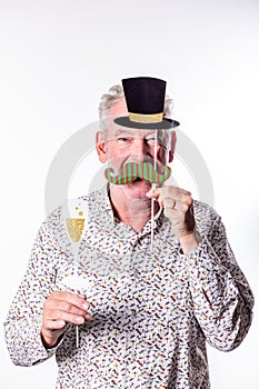 Playful Senior Man with Party Hat and Fake Mustache Props