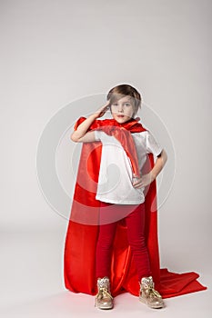 Playful superwoman child posing in studio