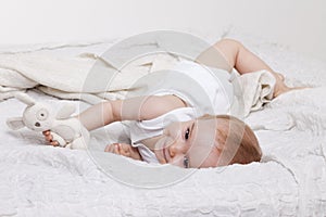 Playful toddler girl in bed