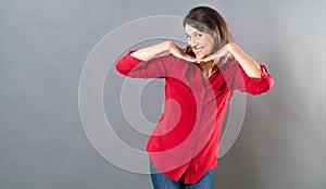 Playful woman posing with fun hand gesture for seduction