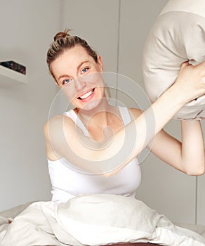 Playful woman throwing a pillow