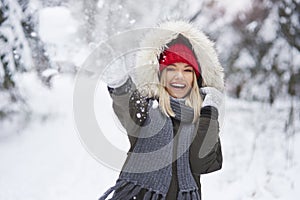 Playful woman throwing snowball