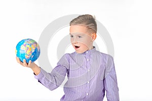 Playful young caucasian school boy holding a globe on white studio background.Boy is surprised