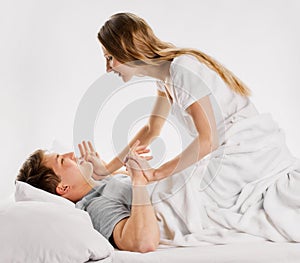 Playful young couple in bed