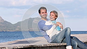 Playful young couple sitting on the beach