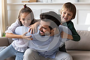 Playful young daddy having fun with energetic little kids.