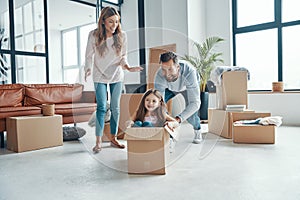Playful young family smiling and unboxing their stuff