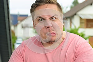 Playful young man pulling an ugly face at the camera