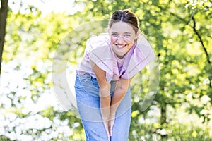 Playful Young Woman Leaning Forward in Park