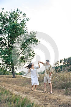 Playful and youthful adult man and woman having fun together in the meadow.
