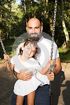 Playfull daughter child with bald man father outdoor