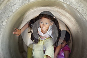 Playground, children and play in tunnel, explore or having fun together. Kindergarten, tube and young girl, kids and