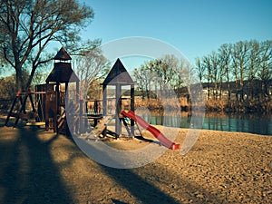 Playground for children, slides and swings, stand on the river bank, late autumn