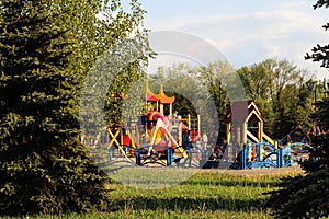 Playground in the DPR on the background of spruce. Children walk on the Playground