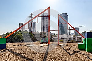 Playground with empty swings in shopping center with buildings in blurred background