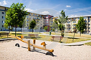 Playground in nature in front of row of newly built block of flats