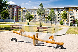 Playground in nature in front of row of newly built block of flats