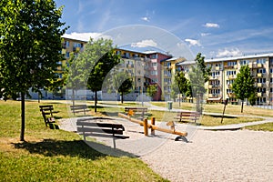 Playground in nature in front of row of newly built block of flats