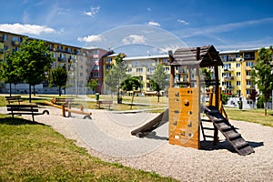 Playground in nature in front of row of newly built block of flats