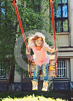 Playground in park. childhood daydream .teen freedom. Happy laughing child girl on swing. Small kid playing in summer