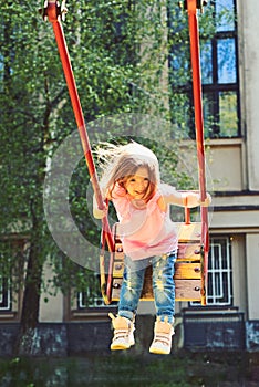 Playground in park. Small kid playing in summer. childhood daydream .teen freedom. Happy laughing child girl on swing