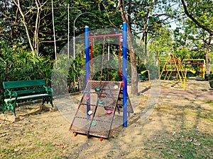 Playground in park with trees and chair