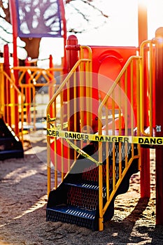 The playground during quarantine is sealed with warning signs, a tape with the word Danger, Coronavirus, Covid-19
