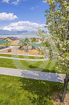 Playground and residential area against lake and mountain under cloudy blue sky