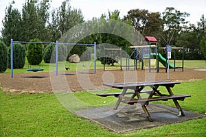 playground with wooden park bench in the forground