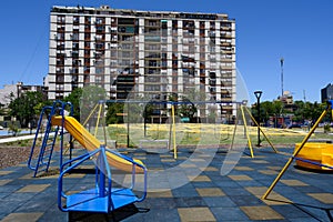Playground and outdoor fitness equipment in colors of La Boca Juniors in front of family dwelling in La Boca, Buenos Aires photo