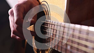 Playing acoustic guitar close-up