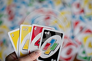 Playing american card game Uno, holding game cards in female hand.